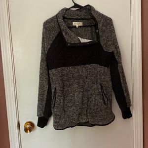 Fleece pullover with snap details on top. Kangaroo pocket. Black and gray.